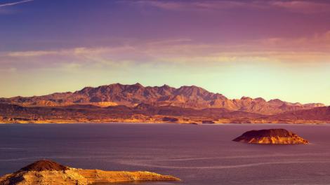 Ein Felsbrocken ragt aus einem friedlichen Stausee hervor