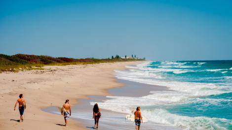 Surfistas paseando por un área de los 115 kilómetros de playas de la zona