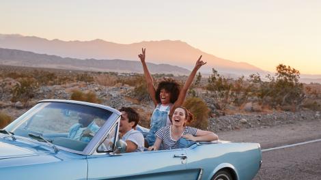 A group of friends cruising down a scenic U.S. highway on a road trip