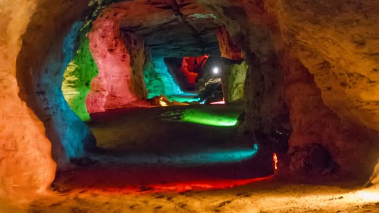 Multicolored lights illuminate the passages within Laurel Caverns 