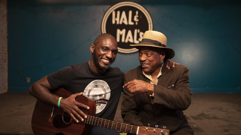 Cedric Burnside 和一位蓝调音乐人在 Hal & Mal's 酒吧表演 Cedric Burnside 和一位蓝调音乐人在 Hal & Mal's 酒吧表演