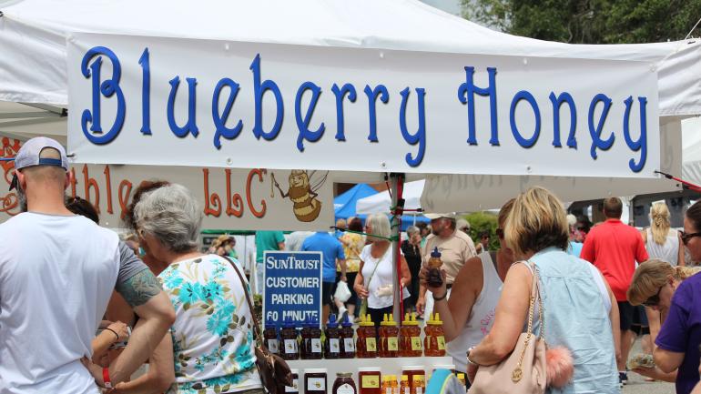 Los asistentes al festival compran productos locales en el Brooksville Blueberry Festival