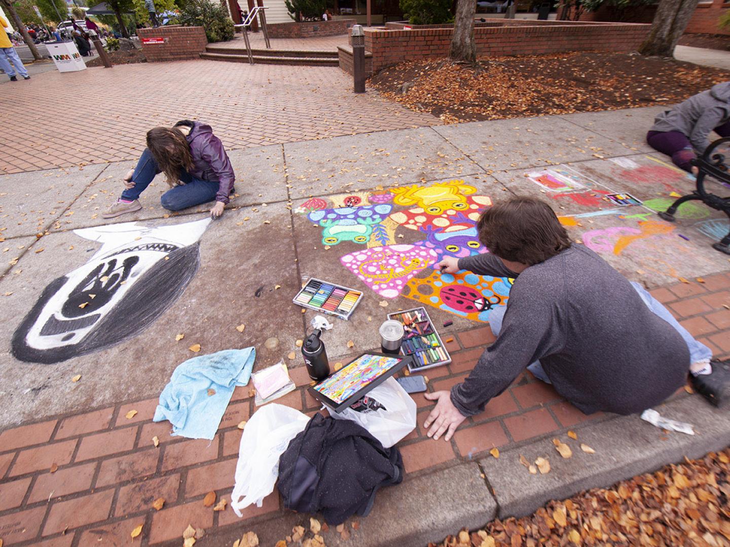 Artistas trabajando durante el Sidewalk Chalk Art Festival en Forest Grove, Oregón