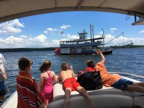 向登上肖托夸湖上的 Chautauqua Belle 明轮船巡游的乘客挥手