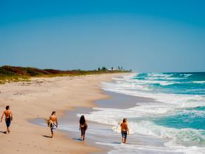 Surfistas paseando por un área de los 115 kilómetros de playas de la zona