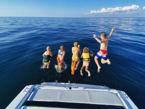 Kids jumping off a boat into Lake Michigan near Holland, Michigan