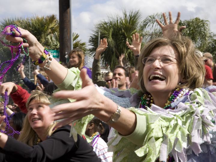 라피엣 마디 그라 퍼레이드에서 묵주를 잡으려고 손을 뻗은 사람들