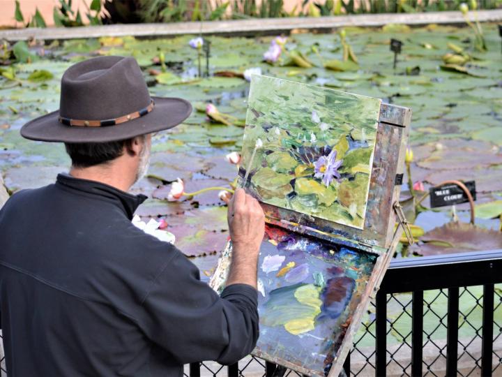 An artist painting the water lilies at Civic League Park during the EnPleinAirTEXAS National Competition & Cinch Roping Fiesta in Texas