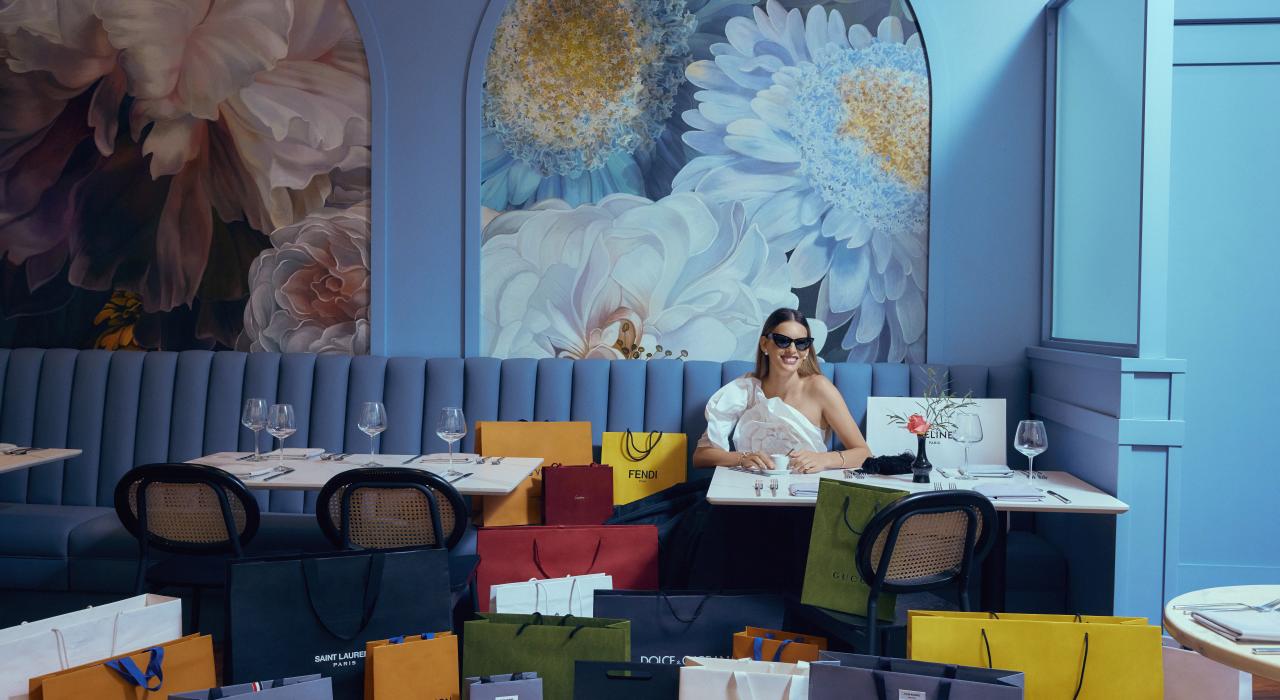 A shopper surrounded by colorful shopping bags at South Coast Plaza in Costa Mesa, California